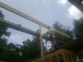 Carpenter setting a ridge beam over a new addition frame — Ice Dam Removal by Roofing Brothers in Clear Spring