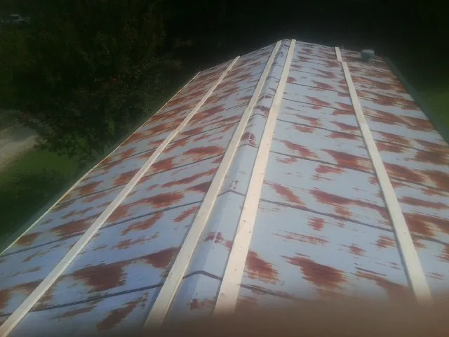 Rusted metal roof panels with new wood purlins before replacement — Storm Damage Roof Repair in Clear Spring by Roofing Brothers