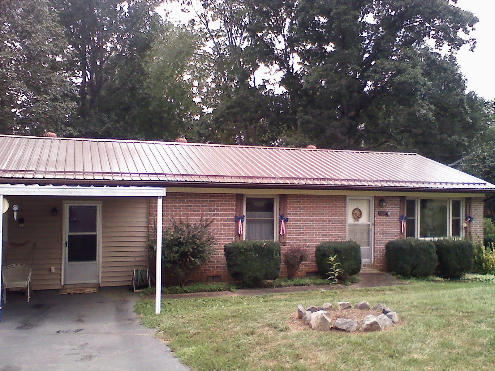Bronze metal roof and carport on a brick ranch home — Roof Repair work by our crew in Clear Spring